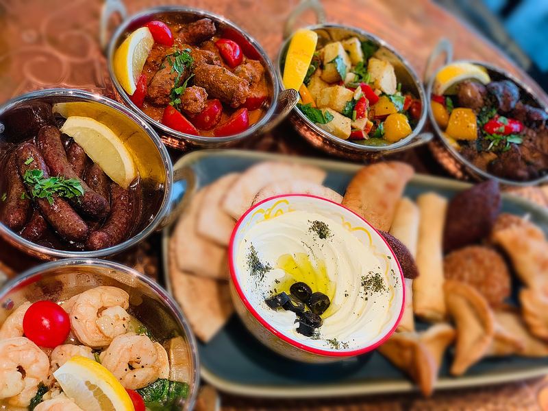 Copper bowls of mezze with labneh, prawns and pastries