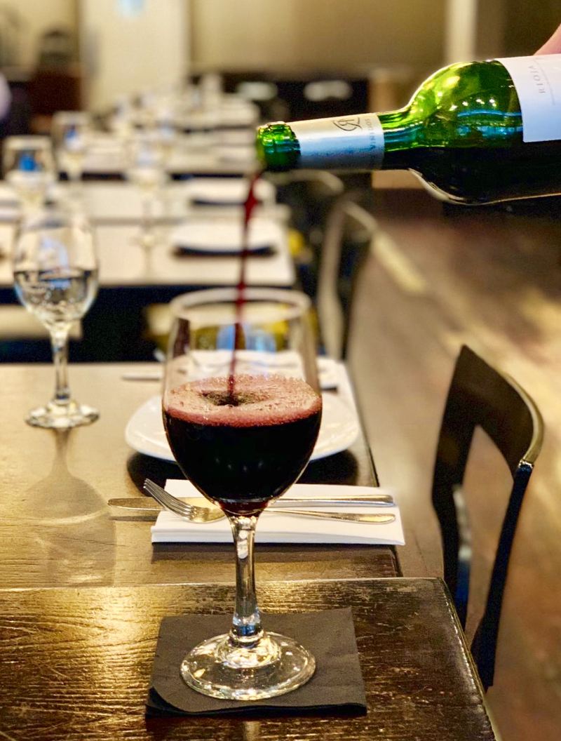 Red wine poured into a glass in the dining room