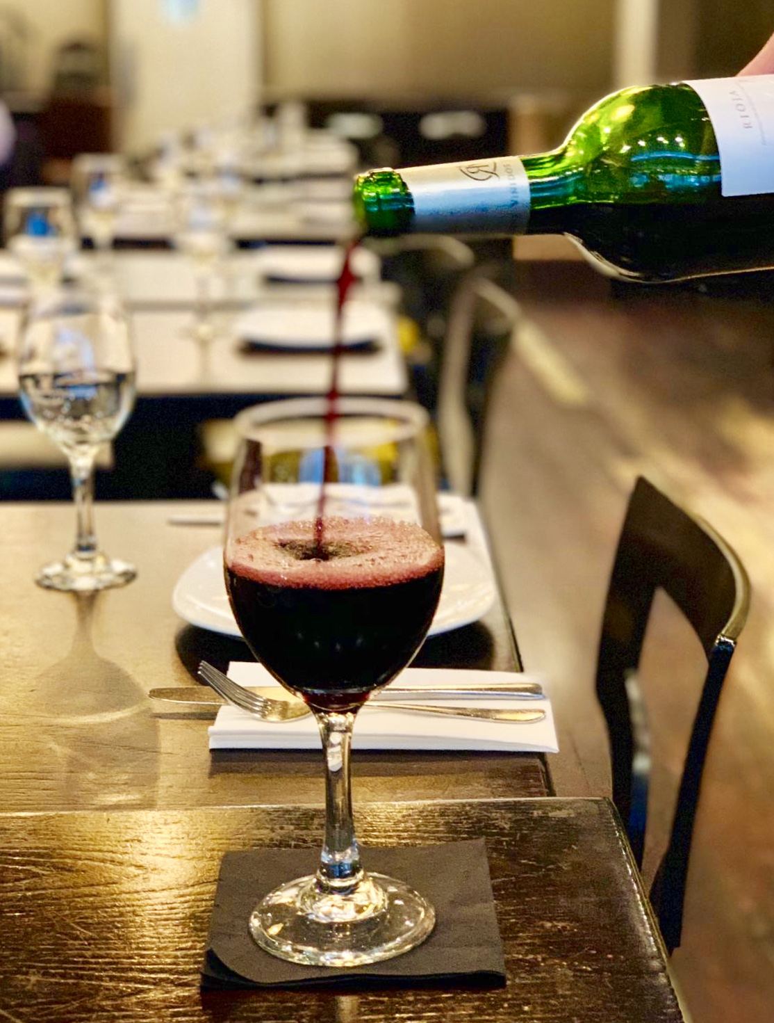 Red wine poured into a glass in the dining room